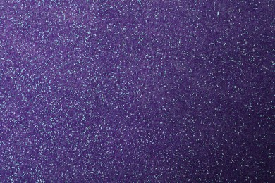 Photo of Beautiful shiny violet glitter as background, closeup