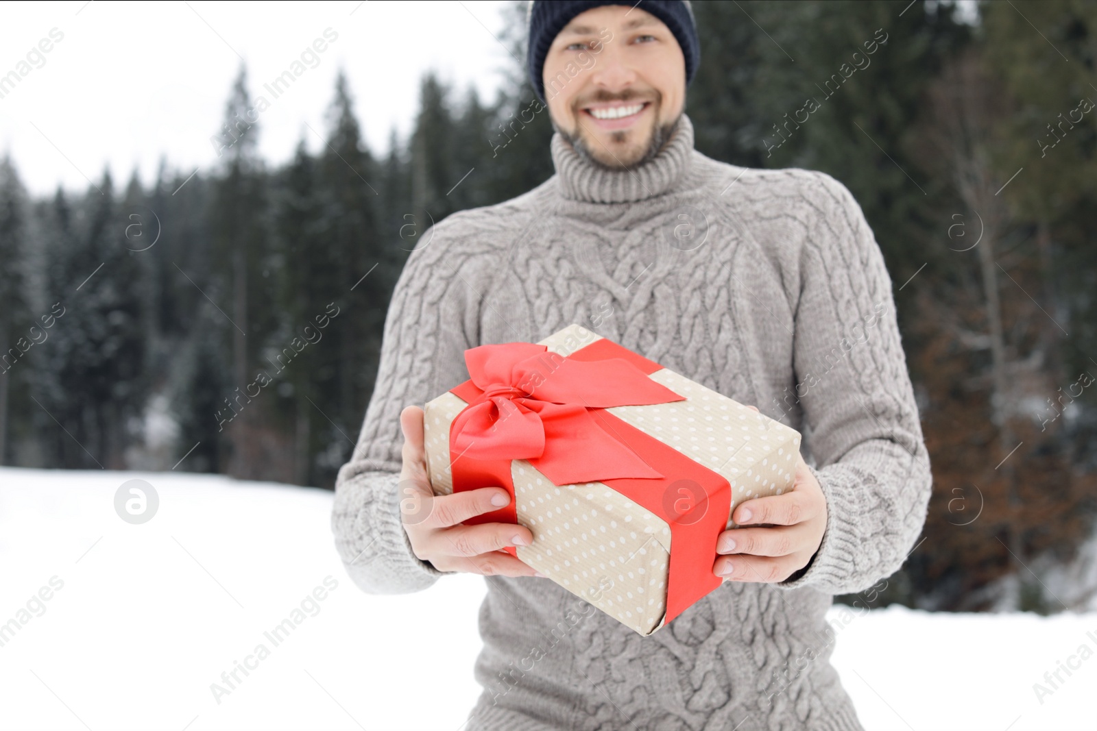 Photo of Happy man with gift box outdoors. Winter vacation