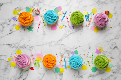 Photo of Colorful birthday cupcakes on marble table, flat lay. Space for text