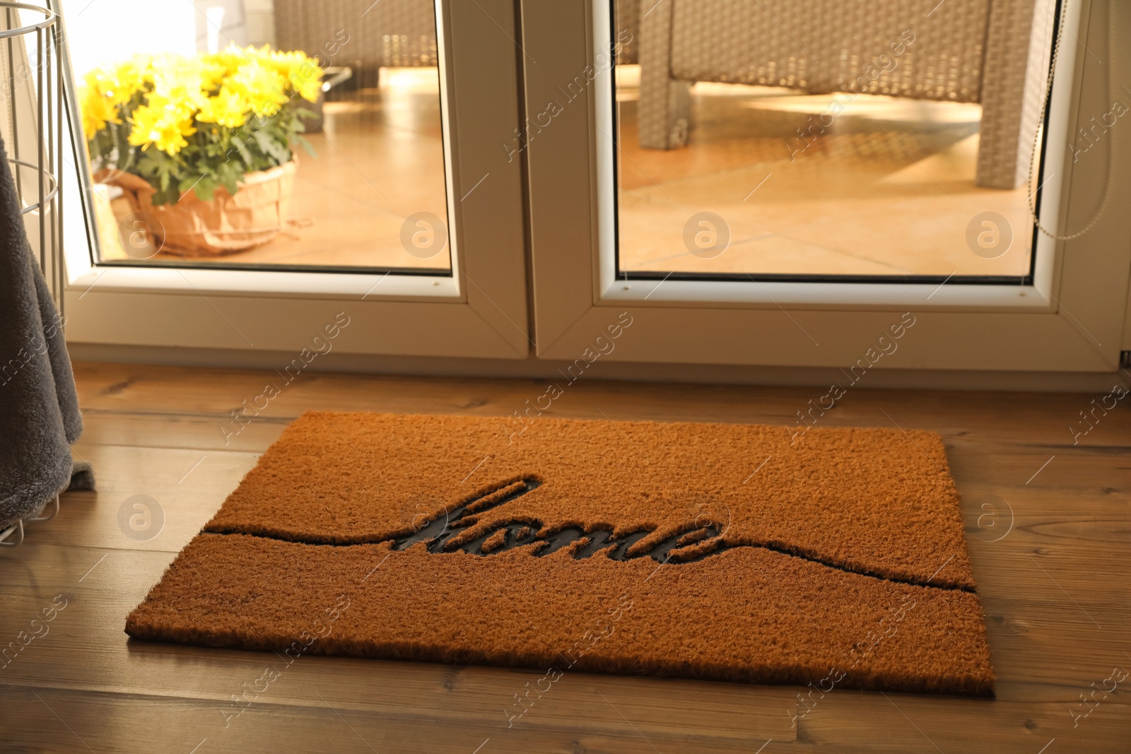 Photo of Doormat with word Home on parquet floor indoors