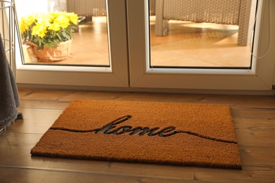 Doormat with word Home on parquet floor indoors