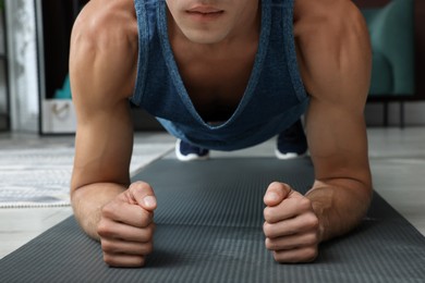 Man doing plank exercise on floor at home, closeup