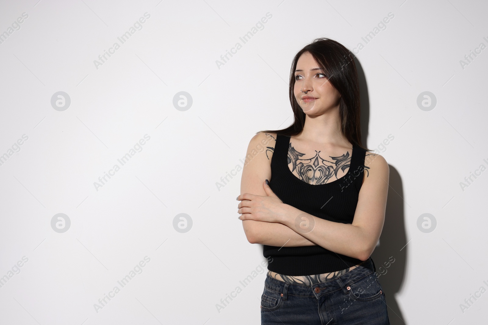 Photo of Portrait of beautiful tattooed woman on light background. Space for text