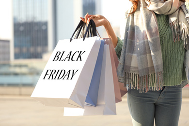 Young woman holding shopping bags outdoors, closeup. Black Friday Sale