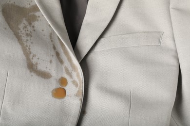 Photo of Dirty jacket with stain of coffee as background, closeup