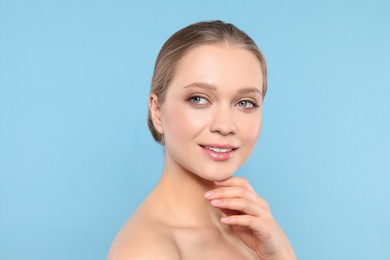 Portrait of young woman with beautiful face on blue background