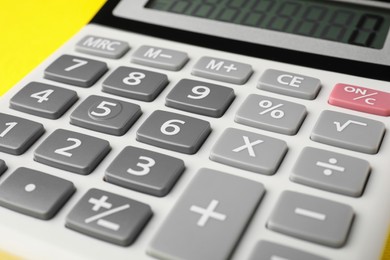 Photo of Calculator on yellow background, closeup. Office equipment