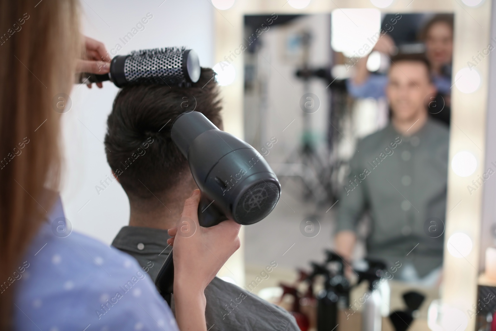 Photo of Professional hairdresser working with client in salon