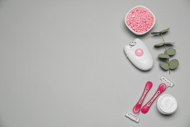Photo of Flat lay composition with epilator and other hair removal products on light grey background. Space for text