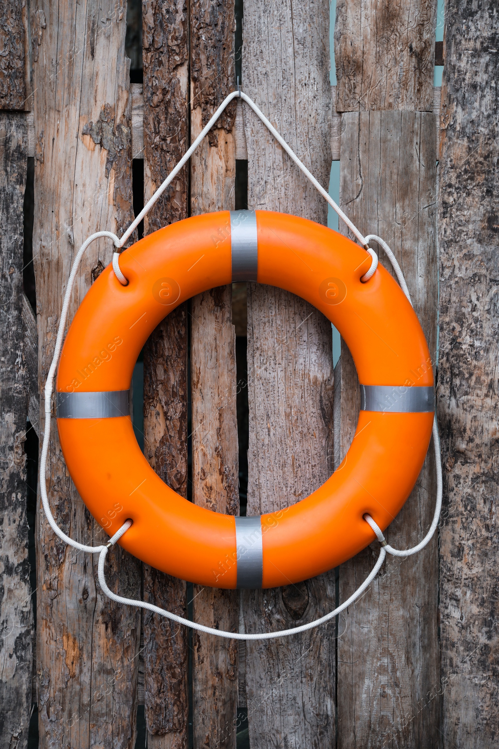 Photo of Orange life buoy hanging on wooden wall