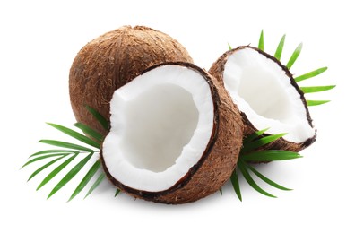 Photo of Fresh ripe coconuts with green leaves on white background