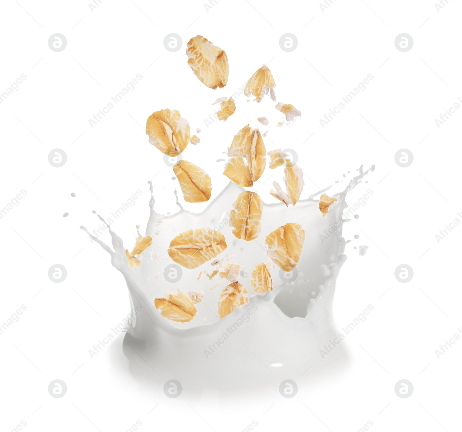 Image of Rolled oats falling into splashing milk on white background