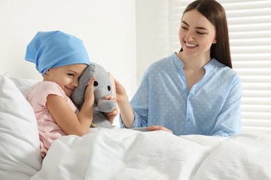 Photo of Childhood cancer. Mother and daughter with toy elephant in hospital
