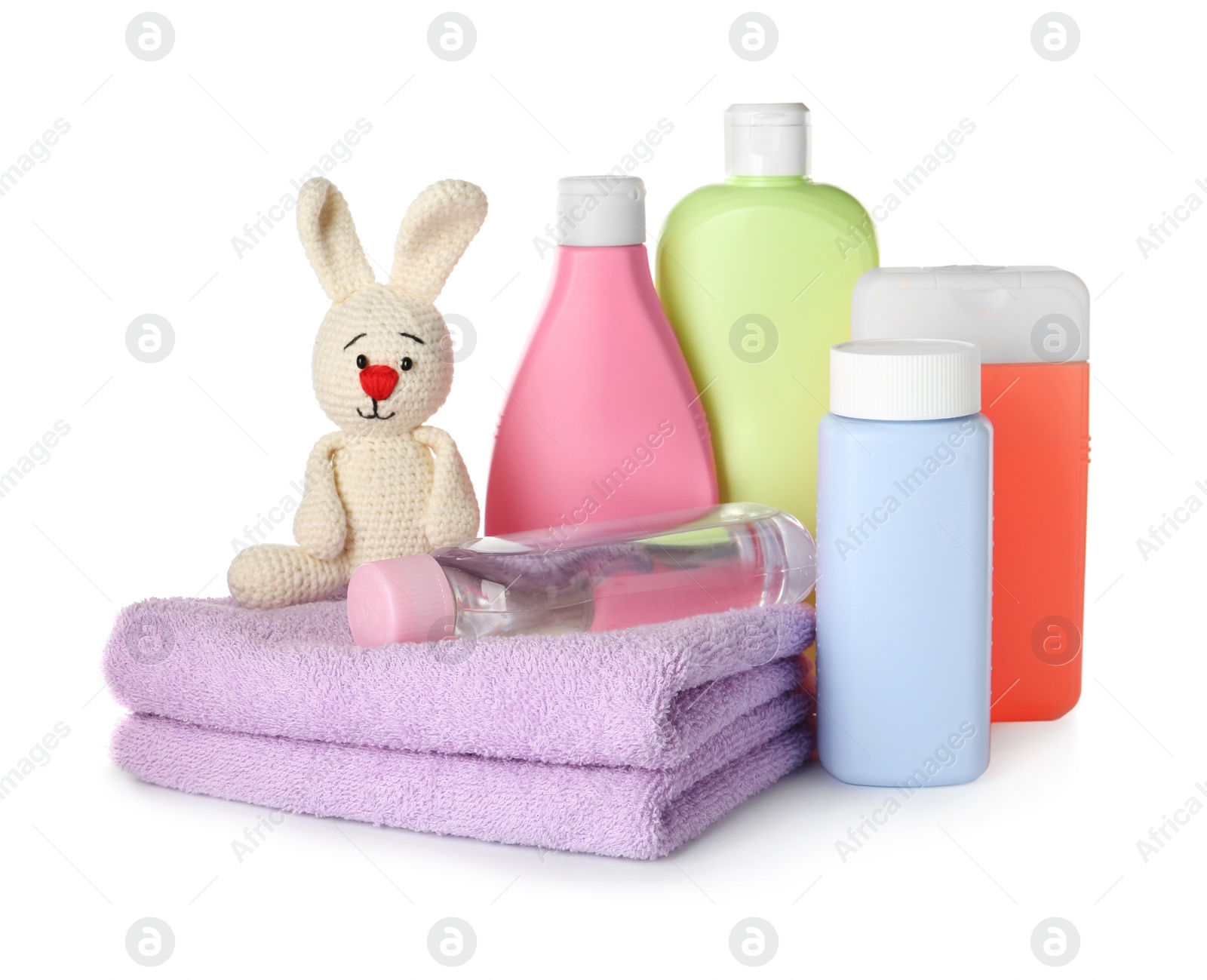 Photo of Bottles of baby cosmetic products, towels and bunny toy on white background
