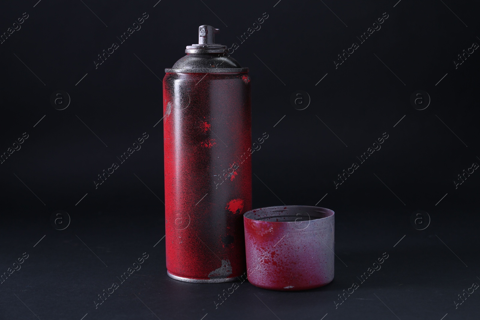 Photo of One spray paint can with cap on dark background