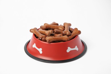 Photo of Red bowl with bone shaped dog cookies on white background
