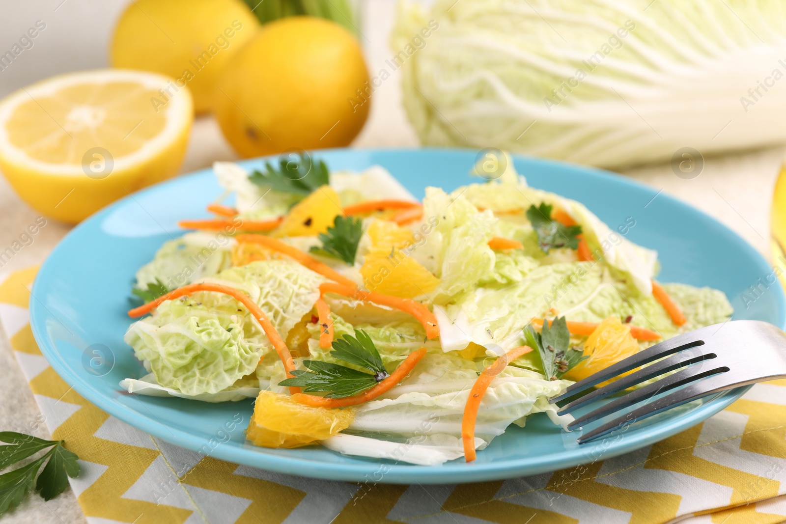 Photo of Tasty salad with Chinese cabbage, products and fork on table, closeup