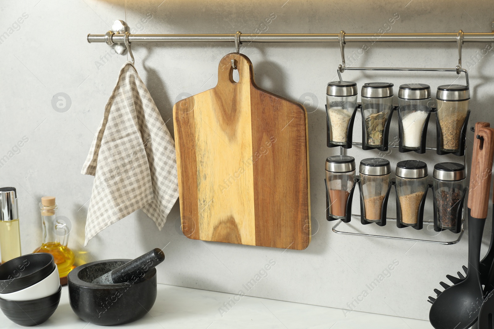 Photo of Wooden cutting boards and other cooking utensils on white countertop in kitchen