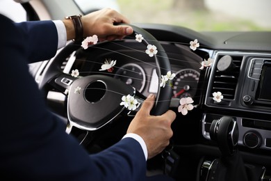 Man enjoying driving car feeling flower scent from ventilation, closeup. Air freshener