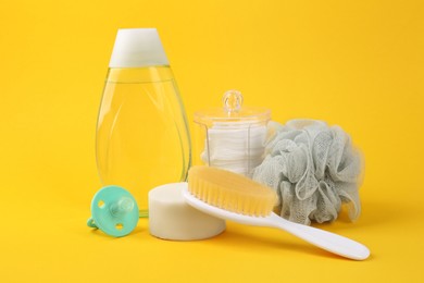 Photo of Different skin care products for baby and accessories on yellow background