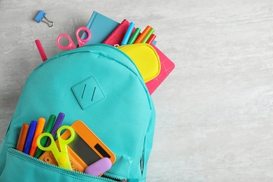 Photo of Stylish backpack with different school stationary on white table, top view. Space for text