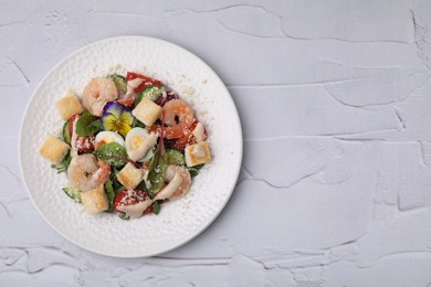 Photo of Delicious Caesar salad with shrimps on white textured table, top view. Space for text