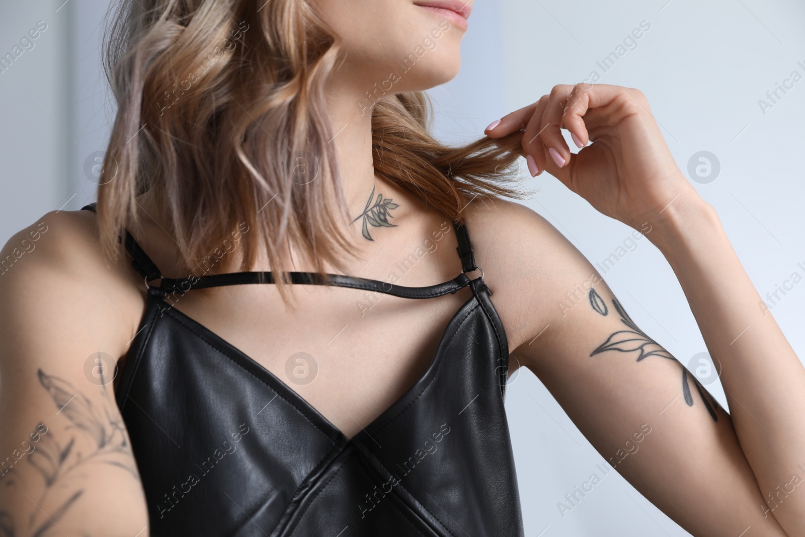 Photo of Beautiful woman with tattoos on body indoors, closeup