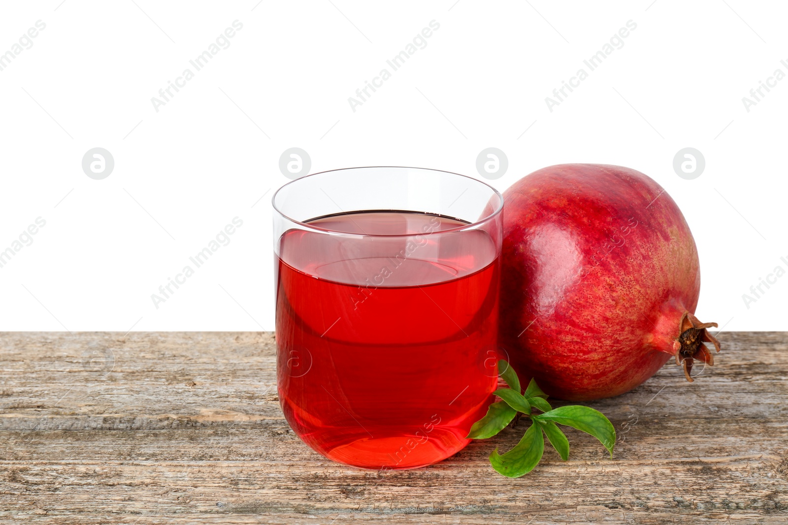 Photo of Refreshing pomegranate juice in glass, leaves and fruit on wooden table against white background. Space for text