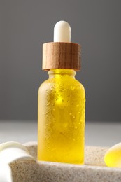 Bottle of face serum on grey background, closeup