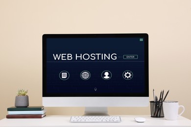 Image of Web hosting service. Comfortable workplace with modern computer on desk near beige wall