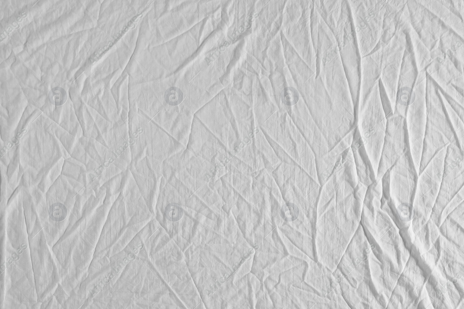 Photo of Crumpled white fabric as background, top view