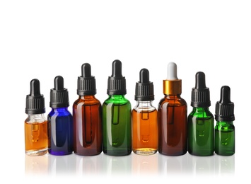 Photo of Cosmetic bottles of essential oils on white background