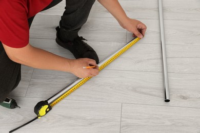 Worker measuring metal pipes for installation, closeup