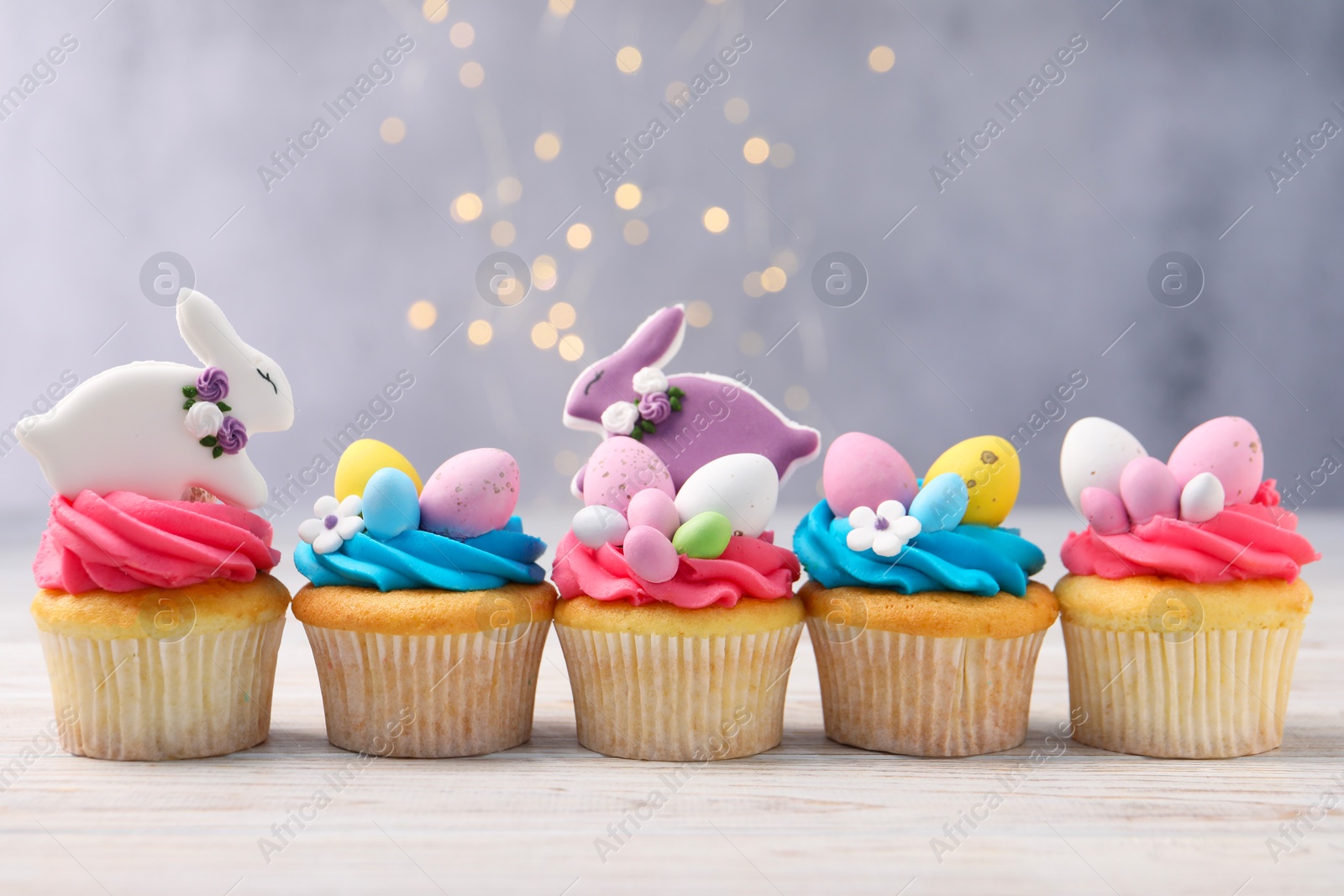 Photo of Tasty decorated Easter cupcakes on wooden table