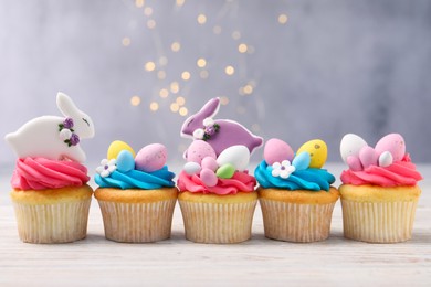 Tasty decorated Easter cupcakes on wooden table