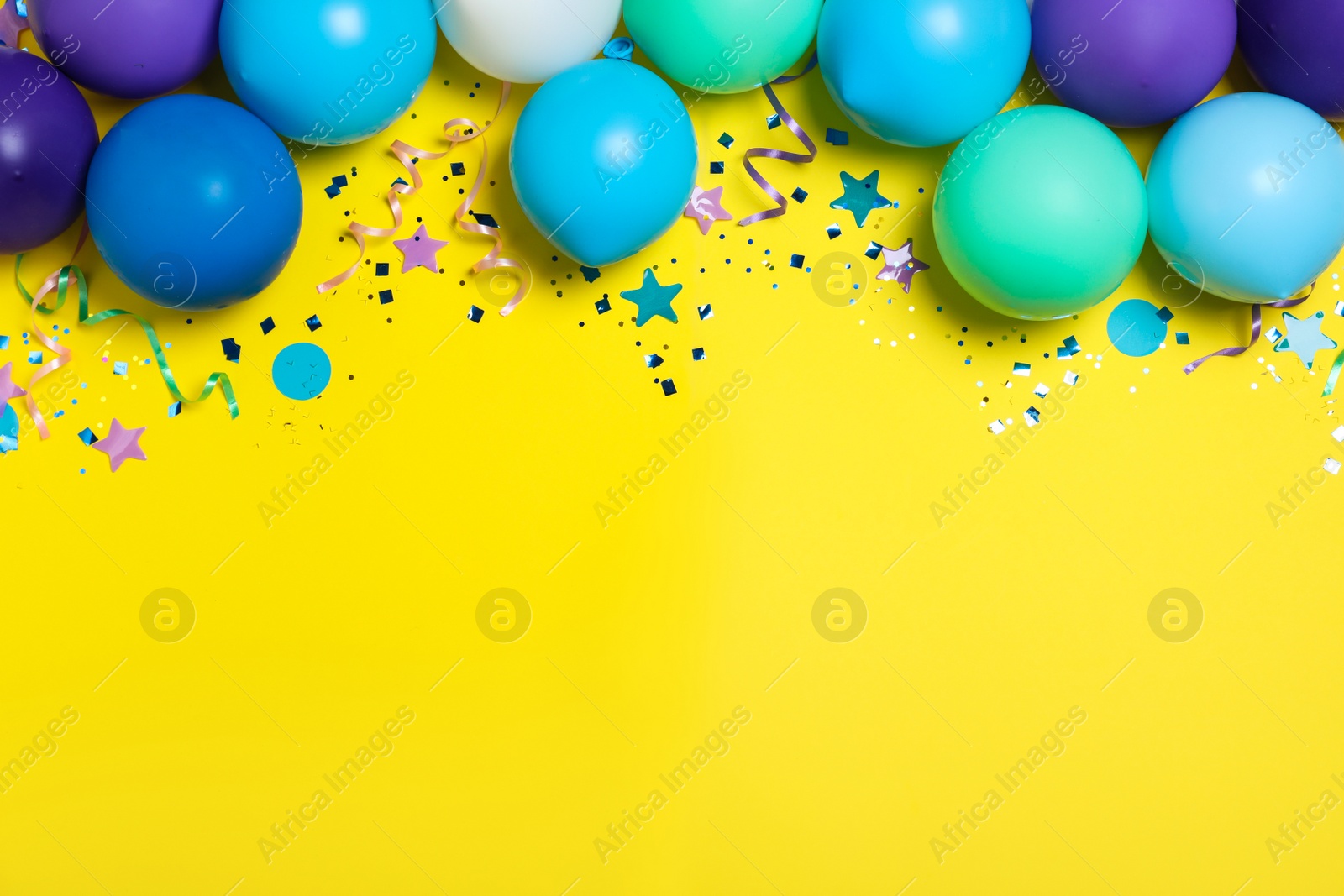 Photo of Flat lay composition with balloons and confetti on yellow background, space for text. Birthday decor