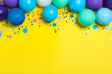 Photo of Flat lay composition with balloons and confetti on yellow background, space for text. Birthday decor