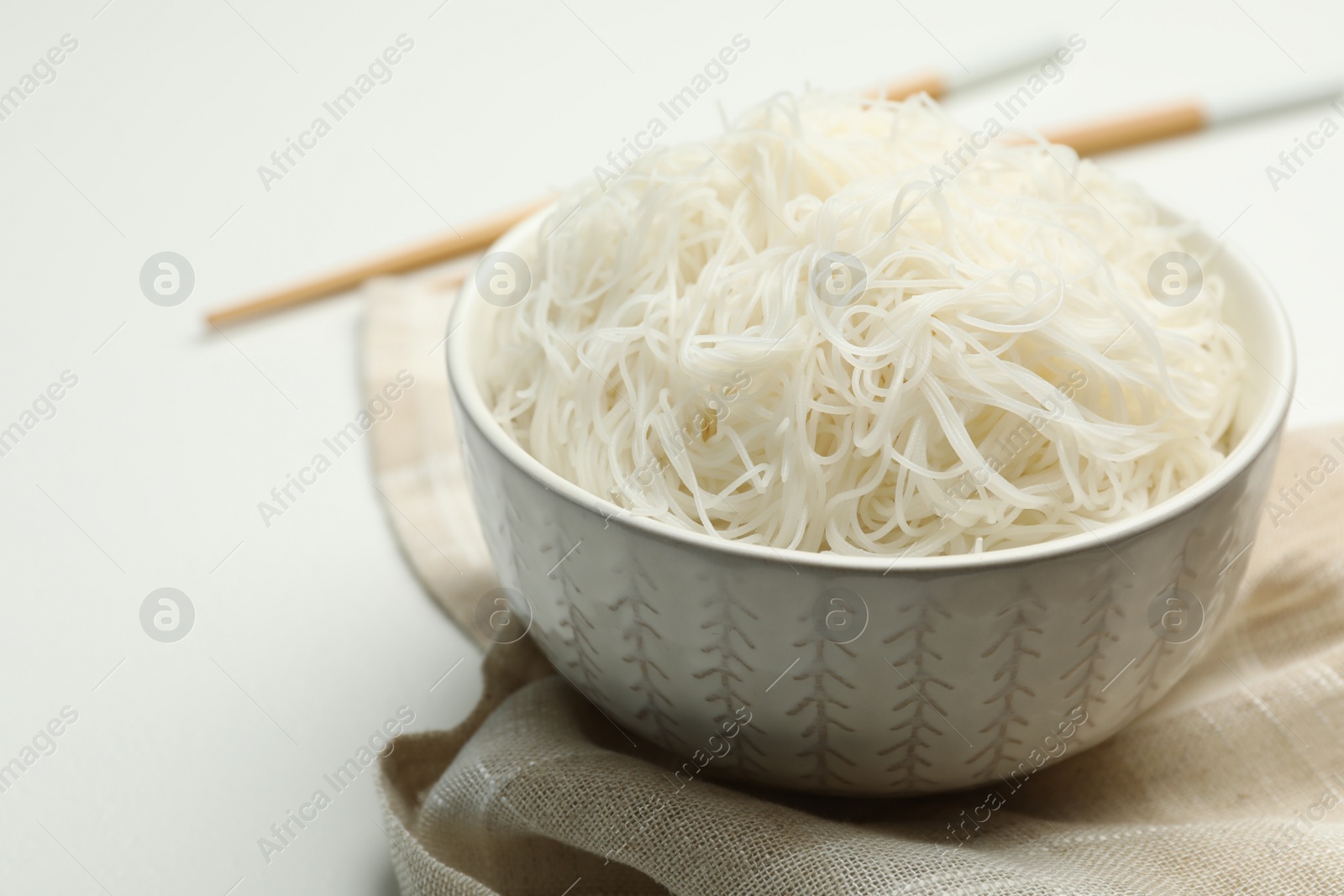 Photo of Tasty cooked rice noodles on white table, closeup