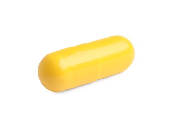 Photo of One yellow pill on white background. Medicinal treatment