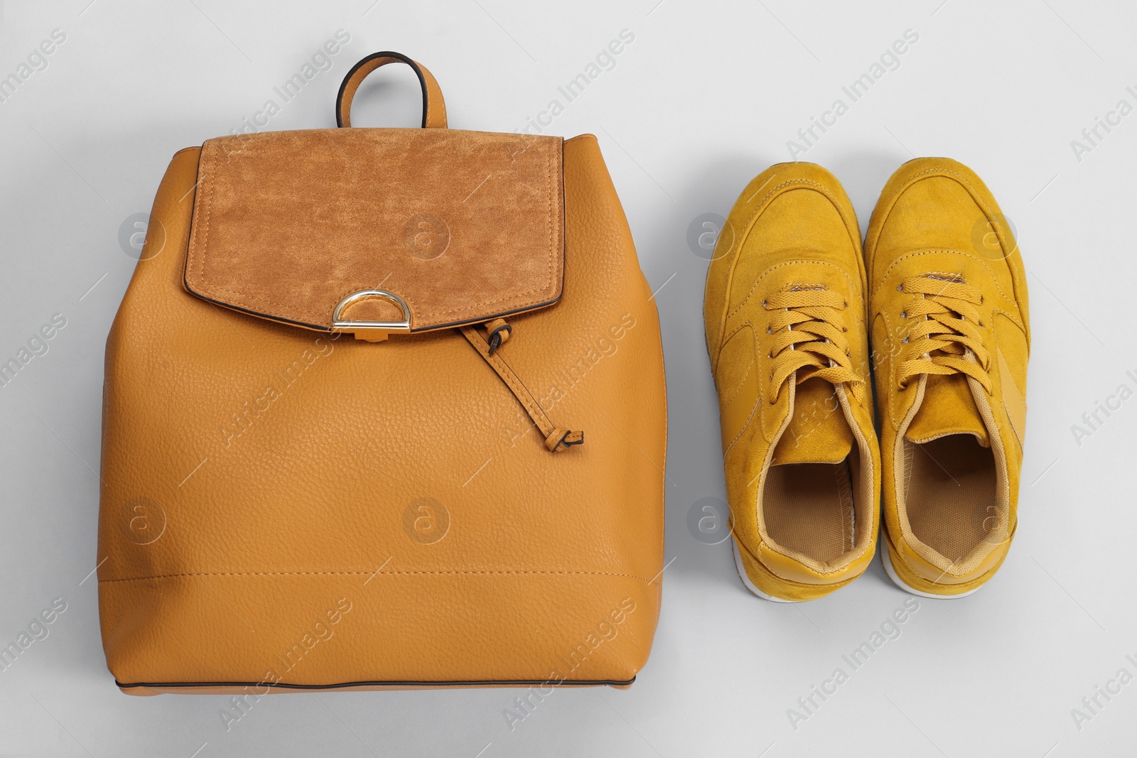 Photo of Backpack and sneakers on light grey background, flat lay