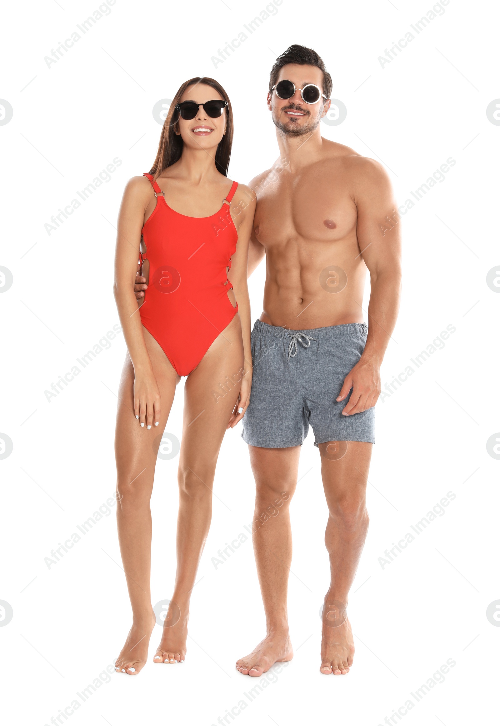 Photo of Young attractive couple in beachwear and sunglasses on white background