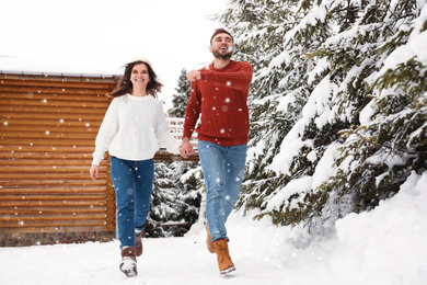Photo of Lovely couple walking together on snowy day. Winter vacation