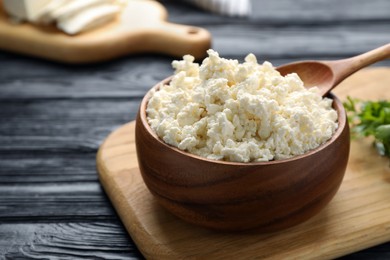 Delicious fresh cottage cheese on black wooden table, closeup
