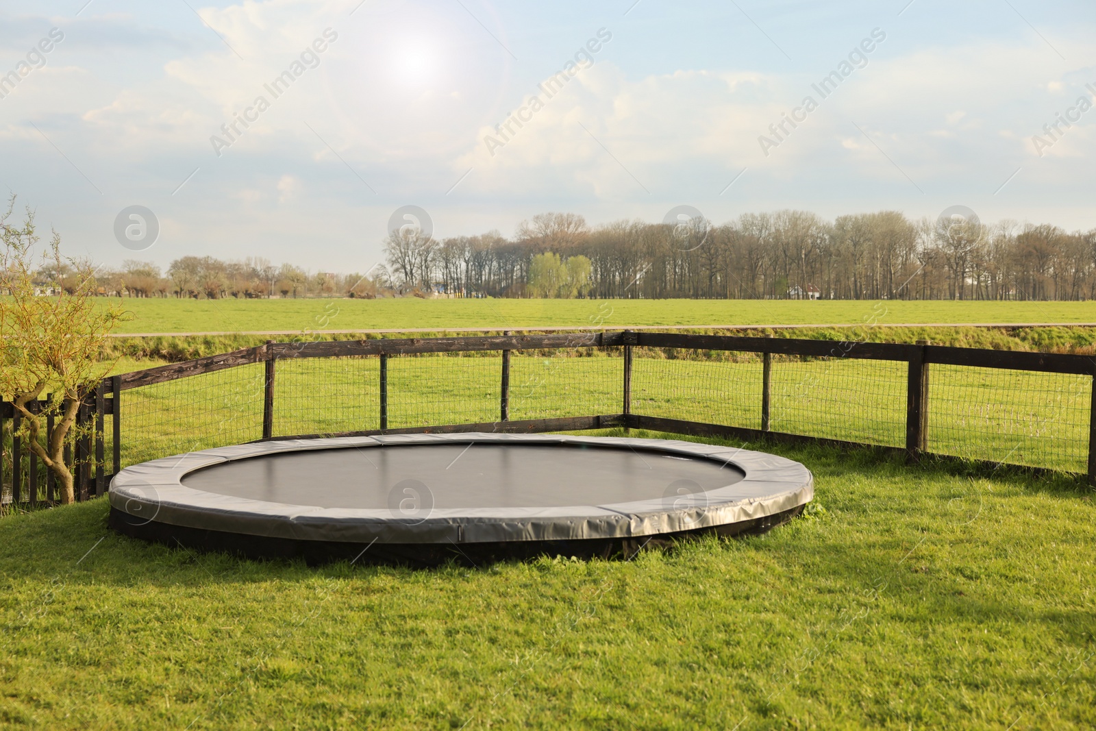 Photo of Croquet equipment and shoes near trampoline on green grass outdoors