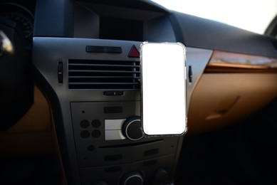 Photo of Holder with modern mobile phone in car. Mockup for design