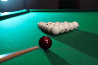 Photo of Striking ball with cue on billiard table