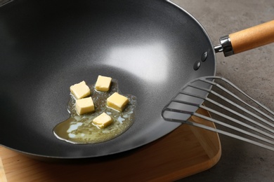 Photo of Frying pan with melting butter on grey table, closeup