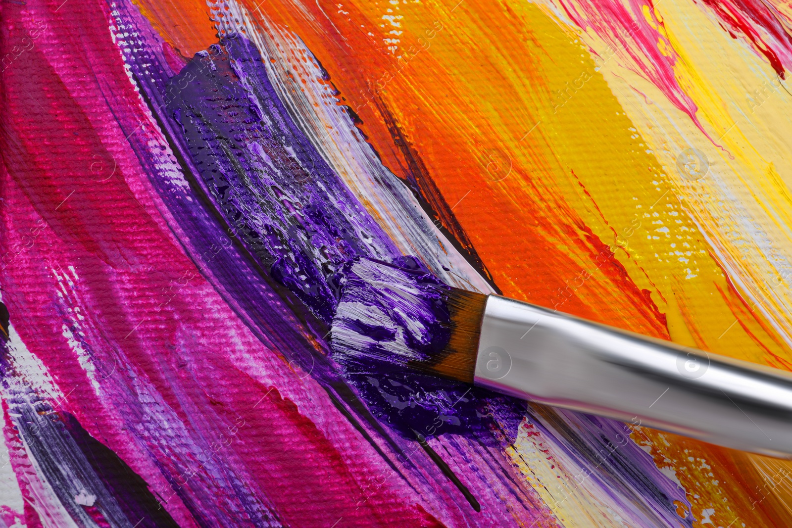 Photo of Painting with colorful oil paints on white canvas, closeup view