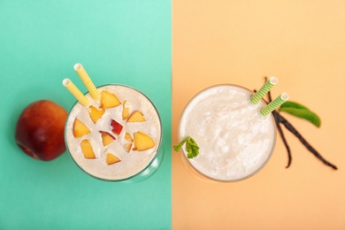 Photo of Glasses with delicious milk shakes on color background, top view