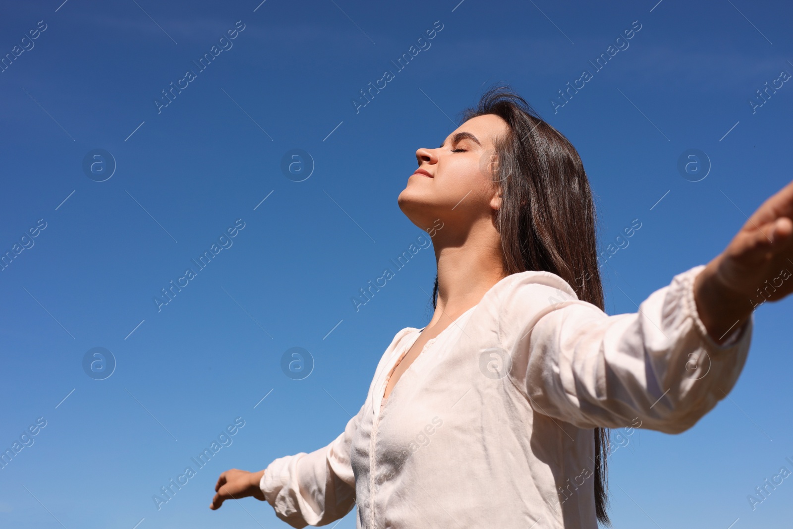 Photo of Portrait of beautiful young woman against blue sky. Space for text